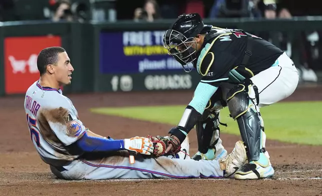Arizona Diamondbacks catcher Gabriel Moreno, right, tags New York Mets' Tyrone Taylor again at home plate dduring the second inning of a baseball game Monday, May 5, 2025, in Phoenix. (AP Photo/Ross D. Franklin)