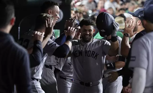New York Yankees' Jasson Domínguez, center, celebrates with teammates in the dugout after hitting a solo home run during the seventh inning of a baseball game against the Athletics, Friday, May 9, 2025, in West Sacramento, Calif. (AP Photo/Godofredo A. Vásquez)