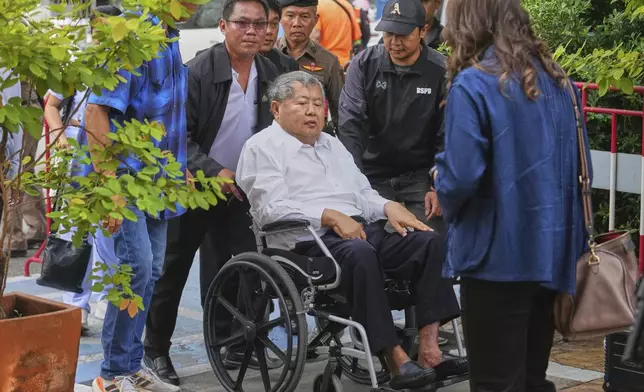 Premchai Karnasuta, the president of Italian-Thai Development Co arrives on a wheelchair at Bang Sue Police Station in Bangkok, Thailand, Friday, May 16, 2025 to surrender to police on criminal negligence charges for the collapse of a Bangkok high-rise during a March 28 earthquake. (AP Photo/Sakchai Lalit)