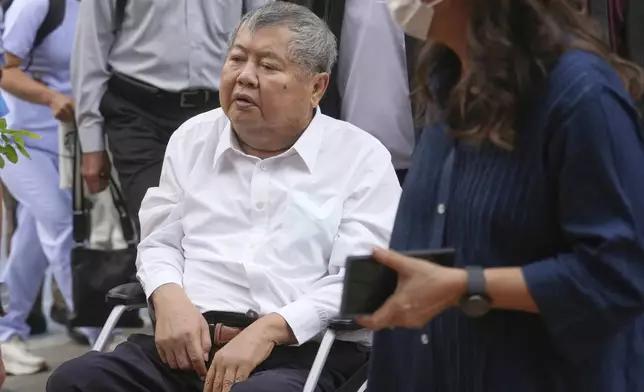 Premchai Karnasuta, the president of Italian-Thai Development Co arrives on a wheelchair at Bang Sue Police Station in Bangkok, Thailand, Friday, May 16, 2025 to surrender to police on criminal negligence charges for the collapse of a Bangkok high-rise during a March 28 earthquake. (AP Photo/Sakchai Lalit)