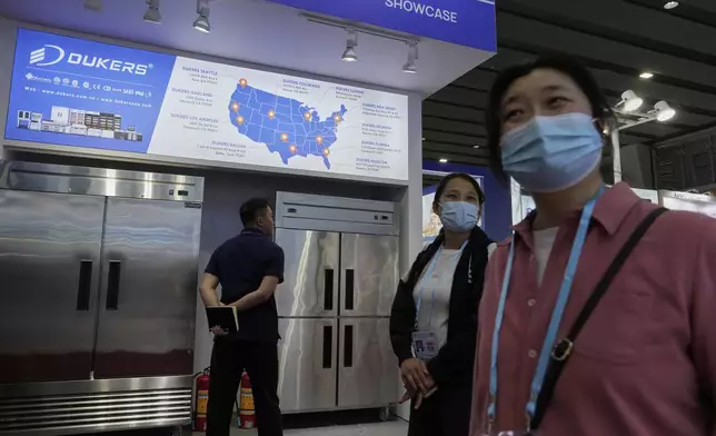 FILE - Visitors past by a map of the United States offices for Dukers, a manufacturer of refrigeration and cooking equipment, at the 137th Canton Fair, in Guangzhou in southern China's Guangdong province on April 15, 2025. (AP Photo/Ng Han Guan, File)