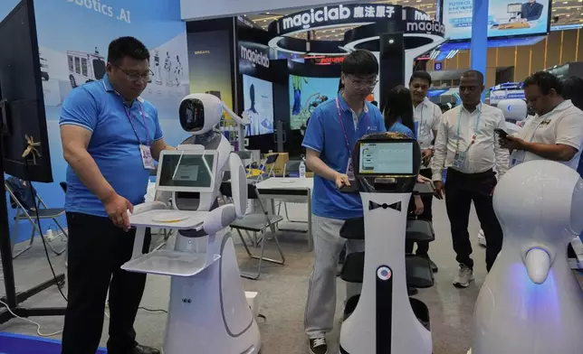 FILE - Vendors from AlphaRobotics.AI show off service robots at the 137th Canton Fair in Guangzhou in southern China's Guangdong province on April 16, 2025. (AP Photo/Ng Han Guan, File)