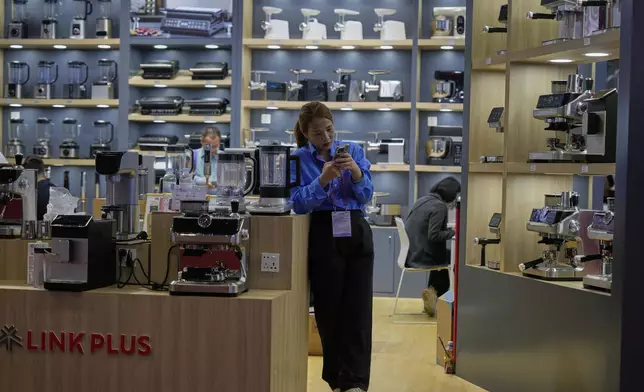 FILE - A vendor of coffee machines waits for customers at the 137th Canton Fair in Guangzhou, in southern China's Guangdong province on April 16, 2025. (AP Photo/Ng Han Guan, File)