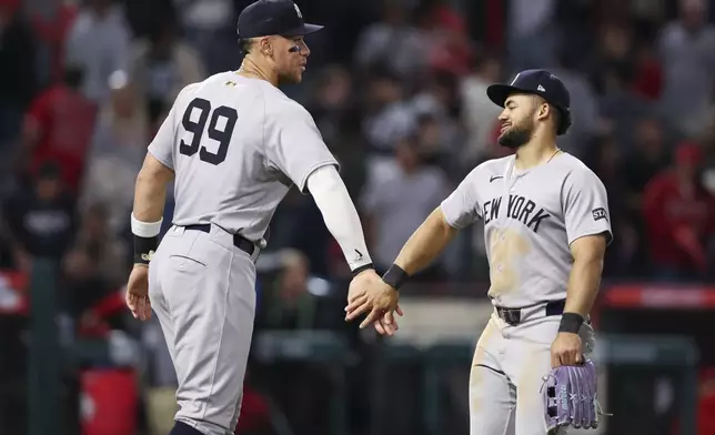 New York Yankees' Aaron Judge (99) and left fielder Jasson Domínguez, right, celebrate after the Yankees defeat the Angels during a baseball game in Anaheim, Calif., Wednesday, May 28, 2025. (AP Photo/Jessie Alcheh)