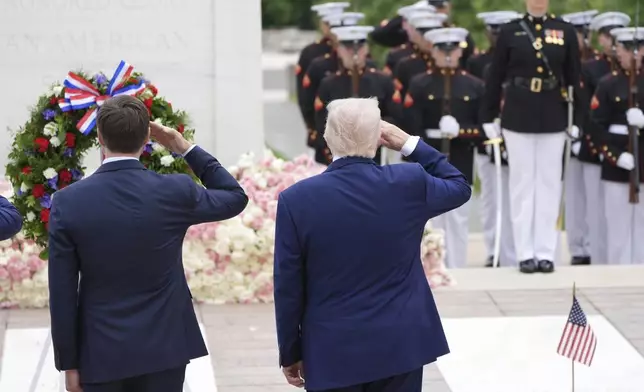 President Donald Trump, right, salutes at the Tomb of the Unknown Soldier, on Memorial Day at Arlington National Cemetery, in Arlington, Va., Monday, May 26, 2025. (AP Photo/Jacquelyn Martin)