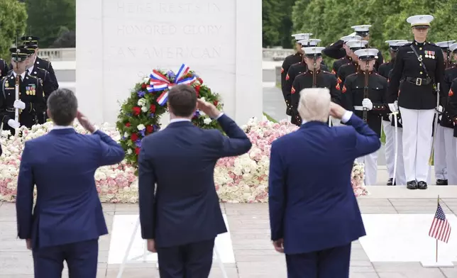 President Donald Trump, standing right, salutes at the Tomb of the Unknown Soldier, on Memorial Day at Arlington National Cemetery, in Arlington, Va., Monday, May 26, 2025. (AP Photo/Jacquelyn Martin)