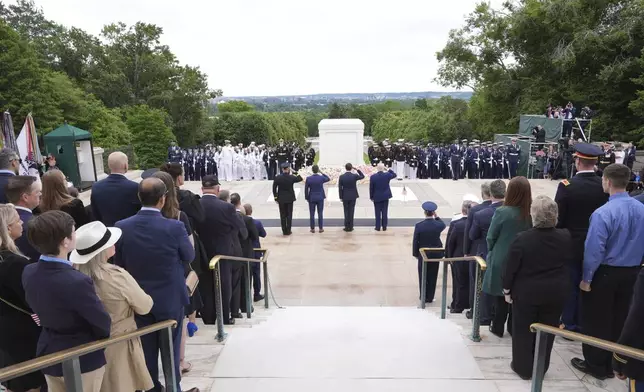 President Donald Trump, standing center right, salutes at the Tomb of the Unknown Soldier, on Memorial Day at Arlington National Cemetery, in Arlington, Va., Monday, May 26, 2025. (AP Photo/Jacquelyn Martin)