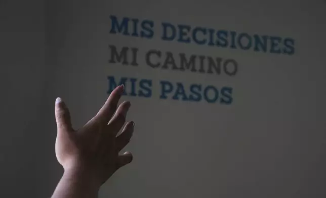 A health worker gestures towards a message that reads in Spanish; "My decisions, my road, my steps" during a tour of the MSI Foundation, an organization that offers information and help to women seeking abortions, in Mexico City, Thursday, May 8, 2025. (AP Photo/Marco Ugarte)