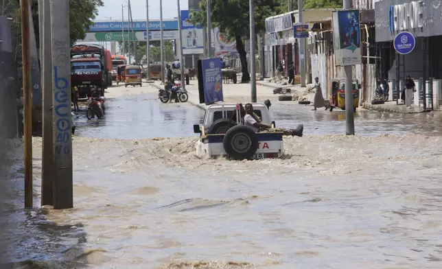 A van drives through floodwater following a heavy downpour in Mogadishu, Somalia, Saturday, May 10, 2025. (AP Photo/Farah Abdi Warsameh)