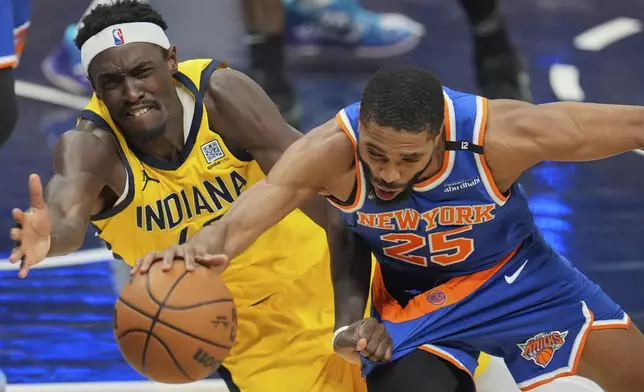 New York Knicks forward Mikal Bridges (25) and Indiana Pacers forward Pascal Siakam, left, dive for the ball during the second half of Game 4 of the Eastern Conference finals of the NBA basketball playoffs in Indianapolis, Tuesday, May 27, 2025. (AP Photo/Michael Conroy)