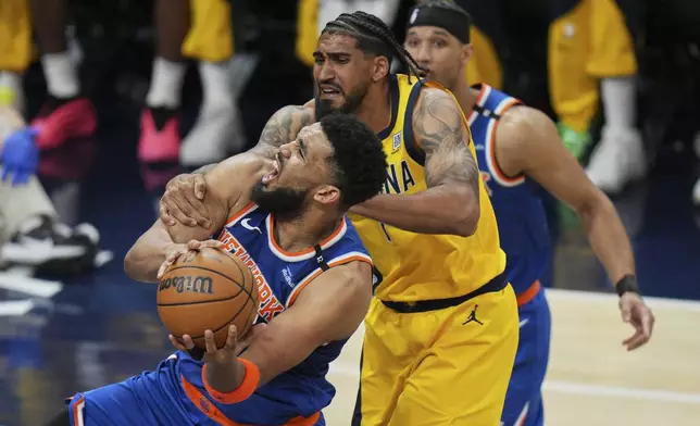 New York Knicks center Karl-Anthony Towns, left, shoots the ball past Indiana Pacers forward Obi Toppin, right, during the second half of Game 4 of the Eastern Conference finals of the NBA basketball playoffs in Indianapolis, Tuesday, May 27, 2025. (AP Photo/AJ Mast)