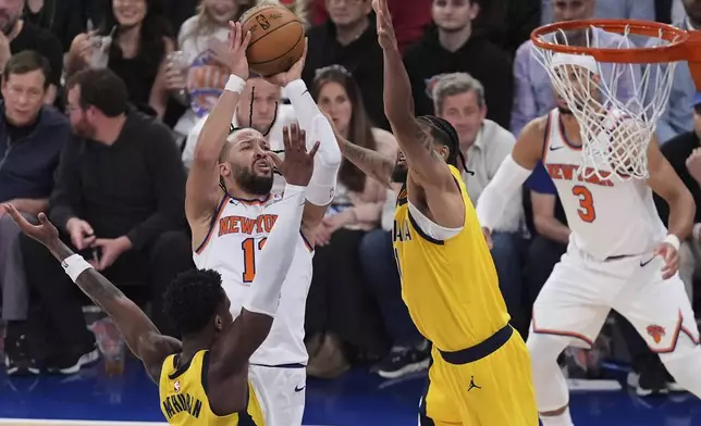 New York Knicks guard Jalen Brunson (11) puts up a shot against Indiana Pacers forward Obi Toppin (1) and guard Bennedict Mathurin (00) during the third quarter of Game 5 of the NBA basketball Eastern Conference final, Thursday, May 29, 2025, in New York. (AP Photo/Frank Franklin II)