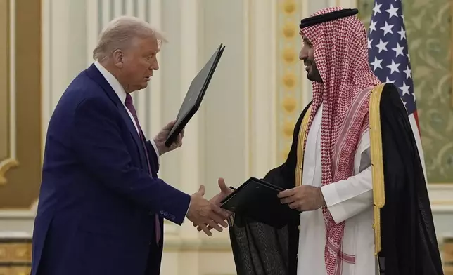 President Donald Trump and Saudi Crown Prince Mohammed bin Salman shake hands after exchanging documents during a signing ceremony at the Royal Palace in Riyadh, Saudi Arabia, Tuesday, May 13, 2025. (AP Photo/Alex Brandon)
