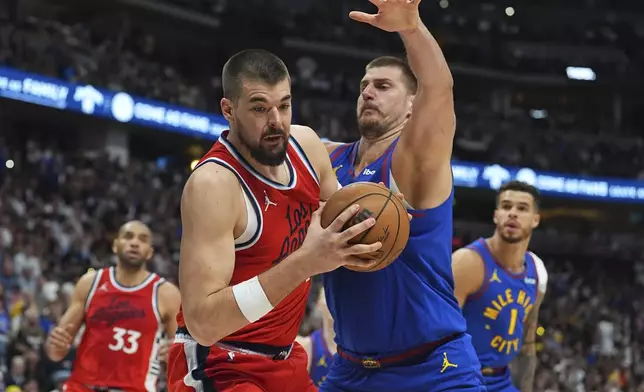 Los Angeles Clippers center Ivica Zubac, front left, pulls in a rebound as Denver Nuggets center Nikola Jokic, front right,defends in the second half of Game 7 of an NBA basketball first-round playoff series Saturday, May 3, 2025, in Denver. (AP Photo/David Zalubowski)