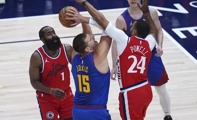Denver Nuggets center Nikola Jokic (15) drives to the basket as Los Angeles Clippers guards James Harden, left, and Norman Powell (24) defend in the first half of Game 7 of an NBA basketball first-round playoff series Saturday, May 3, 2025, in Denver. (AP Photo/David Zalubowski)