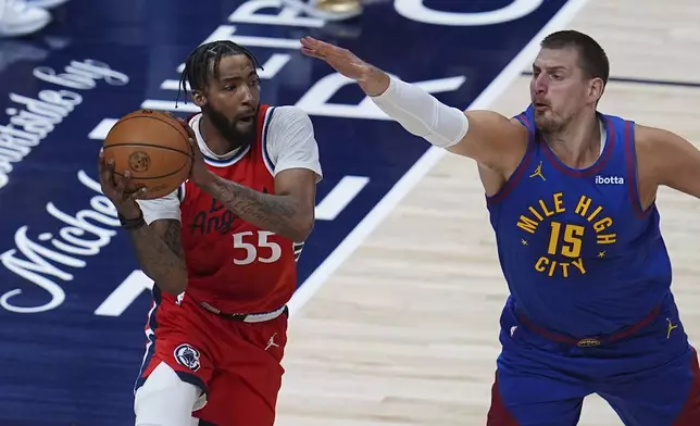 Los Angeles Clippers forward Derrick Jones Jr., left, looks to pass the ball as Denver Nuggets center Nikola Jokic, right, defends in the first half of Game 7 of an NBA basketball first-round playoff series Saturday, May 3, 2025, in Denver. (AP Photo/David Zalubowski)