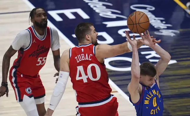 Denver Nuggets guard Christian Braun, right, is fouled by Los Angeles Clippers center Ivica Zubac (40) as Clippers forward Derrick Jones Jr., left, watches in the first half of Game 7 of an NBA basketball first-round playoff series Saturday, May 3, 2025, in Denver. (AP Photo/David Zalubowski)