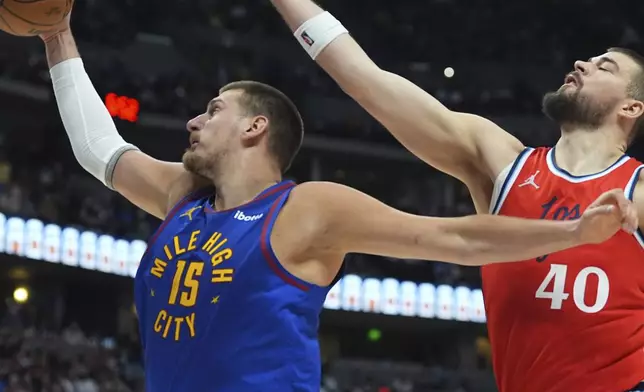Denver Nuggets center Nikola Jokic, left, pulls in a rebound as Los Angeles Clippers center Ivica Zubac, right, defends in the second half of Game 7 of an NBA basketball first-round playoff series Saturday, May 3, 2025, in Denver. (AP Photo/David Zalubowski)