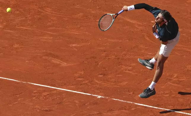 Italy's Lorenzo Musetti serves against Germany's Yannick Hanfmann during their first round match of the French Tennis Open at the Roland Garros stadium, in Paris, Sunday May 25, 2025. (AP Photo/Lindsey Wasson)