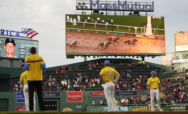 Boston Red Sox players, including right fielder Wilyer Abreu (52), watch the finish of the Kentucky Derby horse race during a rain delay in a baseball game against the Minnesota Twins, Saturday, May 3, 2025, in Boston. (AP Photo/Robert F. Bukaty)