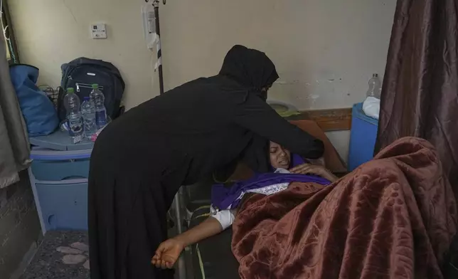 Salwa Faraj cares for her sister, Asmaa Faraj, who was injured in an Israeli army strike, at Nasser Hospital in Khan Younis, Gaza Strip, Tuesday, May 6, 2025. (AP Photo/Abdel Kareem Hana)