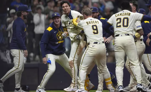Milwaukee Brewers' Christian Yelich (22) is congratulated by teammates after hitting a walk off grand slam during the 10th inning of a baseball game against the Milwaukee Brewers, Tuesday, May 27, 2025, in Milwaukee. (AP Photo/Aaron Gash)