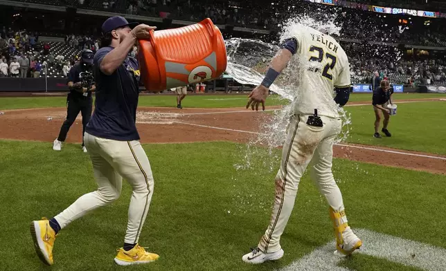 Milwaukee Brewers' Christian Yelich (22) is splashed by Garrett Mitchell after hitting a walk off grand slam during the 10th inning of a baseball game against the Boston Red Sox, Tuesday, May 27, 2025, in Milwaukee. (AP Photo/Aaron Gash)