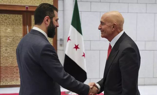 In this photo released by the Syrian official news agency SANA, Syria's interim President Ahmad al-Sharaa, left, shakes hands with U.S. Ambassador to Turkey and Special Envoy to Syria Tom Barrack, in Damascus, Syria, May 29, 2025. (SANA via AP)