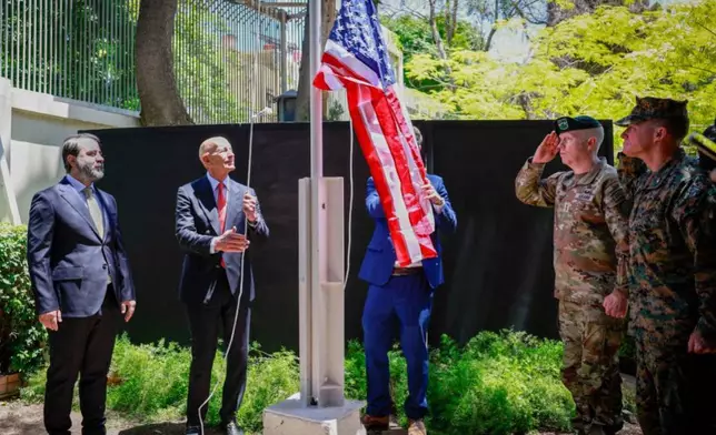 In this photo released by the Syrian official news agency SANA, U.S. Ambassador to Turkey and Special Envoy to Syria Tom Barrack raises the American flag at the U.S. ambassador's residence in Damascus, Syria, Thursday, May 29, 2025. (SANA via AP)