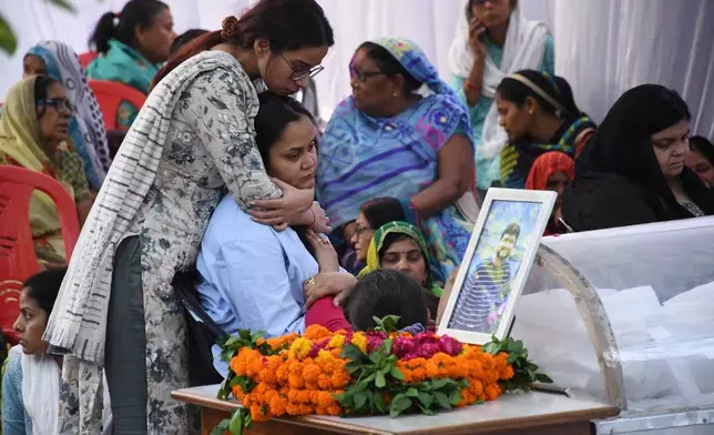 A relative consoles Aishanya Dwivedi, sitting, during the cremation ceremony in Kanpur, India, of her husband Shubham Dwivedi who was killed by militants at Pahalgam in Indian controlled Kashmir, Thursday, April 24, 2025. (AP Photo/Vaibhav Shukla)
