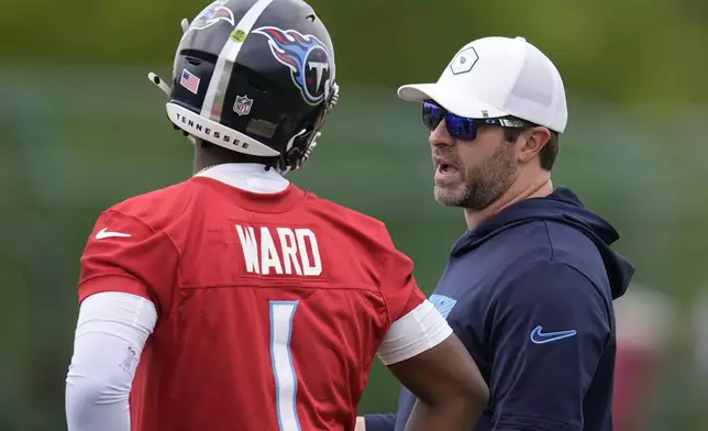 Tennessee Titans head coach Brian Callahan, right, talks to quarterback Cam Ward (1) during the NFL football team's rookie minicamp Saturday, May 10, 2025, in Nashville, Tenn. (AP Photo/George Walker IV)