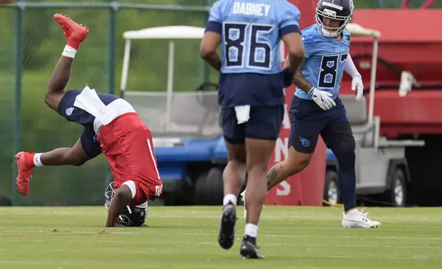 Tennessee Titans quarterback Cam Ward (1) rolls across the grass at the end of the NFL football team's rookie minicamp practice Saturday, May 10, 2025, in Nashville, Tenn. (AP Photo/George Walker IV)