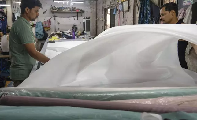 FILE - Workers sort clothes at a factory located in a slum in Dharavi, Mumbai, India, Thursday, April 10, 2025. (AP Photo/Rafiq Maqbool, File)