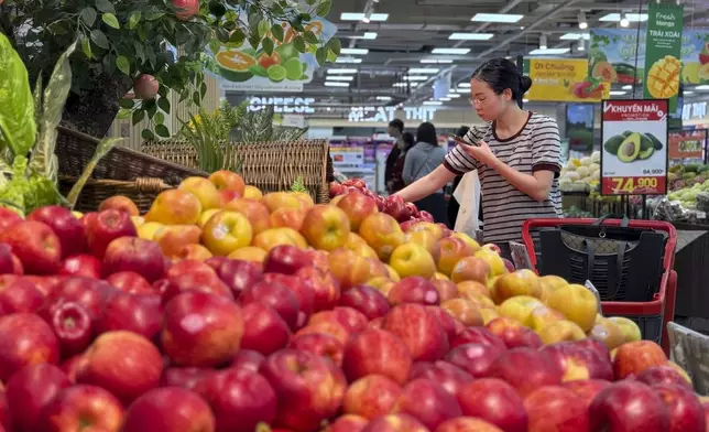 FILE - A shopper picks up imported apples at a supermarket in Hanoi, Vietnam on Thursday, April 10, 2025. (AP Photo/Hau Dinh, File)