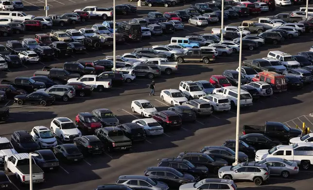 FILE - A person walks through a parking lot at Harry Reid International Airport, Wednesday, April 9, 2025, in Las Vegas. (AP Photo/John Locher, File)