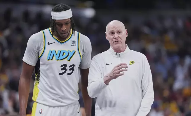 Indiana Pacers center Myles Turner (33) talks to head coach Rick Carlisle in the second half of Game 4 against the Cleveland Cavaliers in the Eastern Conference semifinals of the NBA basketball playoffs in Indianapolis, Sunday, May 11, 2025. (AP Photo/Michael Conroy)