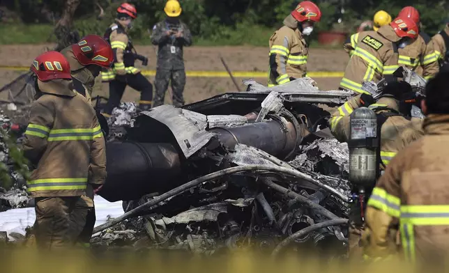 South Korean firefighters and military officers work at the scene of a South Korean navy plane's crash in Pohang, South Korea, Thursday, May 29, 2025. (Lee Mu-yeul/Newsis via AP)
