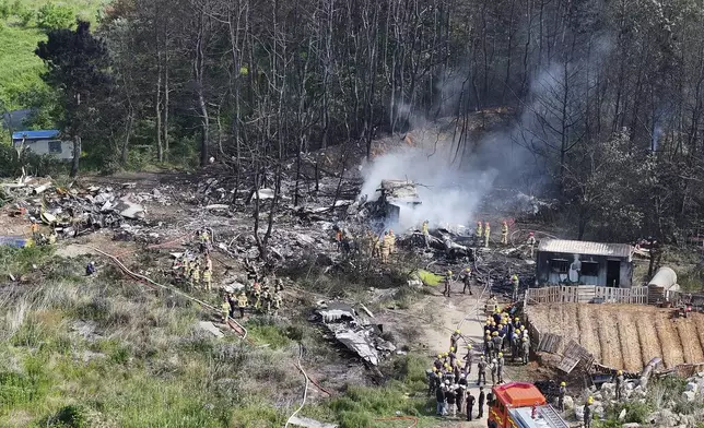 South Korean firefighters and military officers work at the scene of a South Korean navy plane's crash in Pohang, South Korea, Thursday, May 29, 2025. (Yun Kwan-shik/Yonhap via AP)