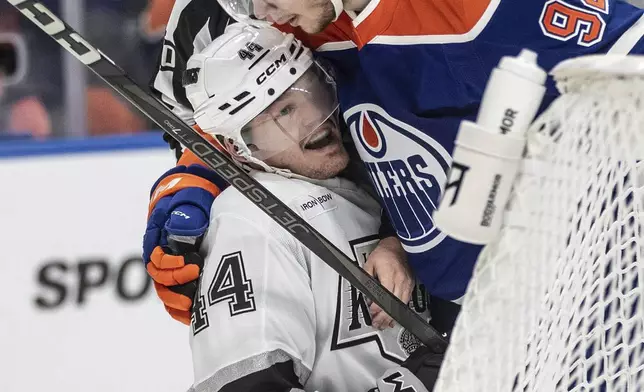 Los Angeles Kings' Mikey Anderson (44) and Edmonton Oilers' Vasily Podkolzin (92) rough it up during the first period of Game 6 of an NHL hockey first-round playoff series in Edmonton, Alberta, Thursday, May 1, 2025. (Jason Franson/The Canadian Press via AP)