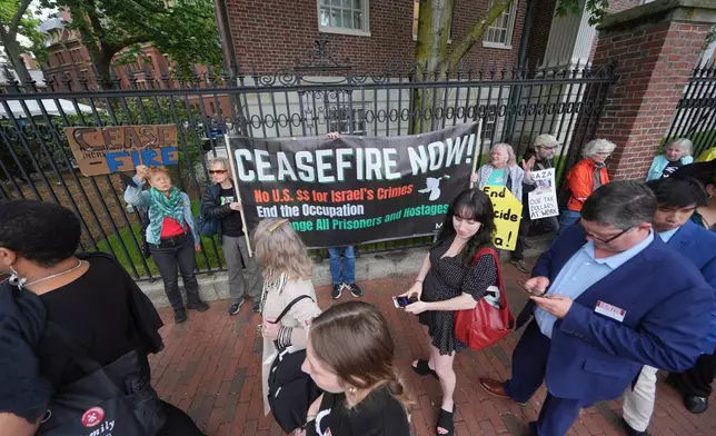 Guests for Harvard's commencement walk past protesters outside Harvard yard prior to commencement ceremonies, Thursday, May 29, 2025 in Cambridge, Mass. (AP Photo/Charles Krupa)