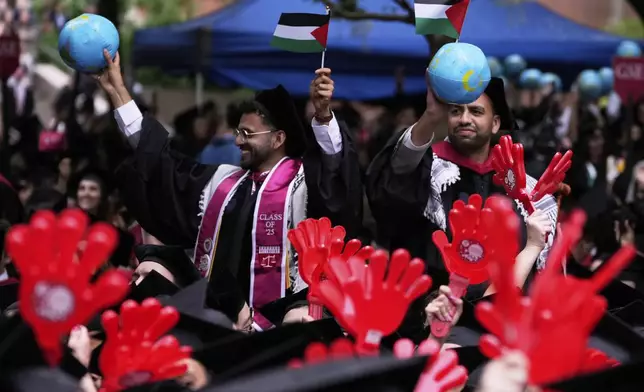 Two graduates wave Palestinian flags during commencement ceremonies at Harvard University, Thursday, May 29, 2025, in Cambridge, Mass. (AP Photo/Charles Krupa)