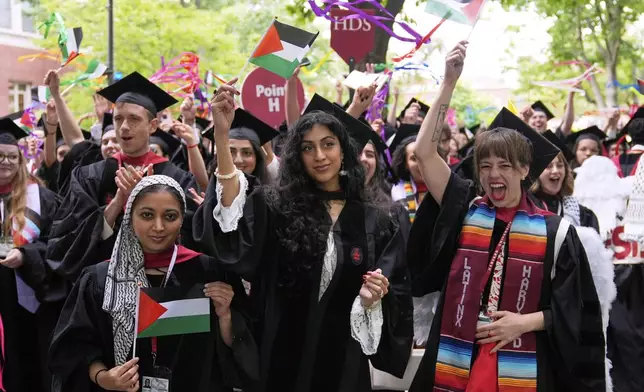 Graduates wave Palestinian flags during commencement ceremonies at Harvard University, Thursday, May 29, 2025, in Cambridge, Mass. (AP Photo/Charles Krupa)