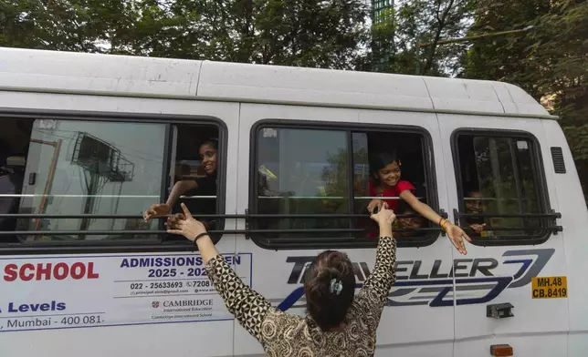 Teacher Shaila Desale says goodbye to her students as they leave the Signal Shala school in a school bus in Thane near Mumbai, India, April 3, 2025. (AP Photo/Rafiq Maqbool)