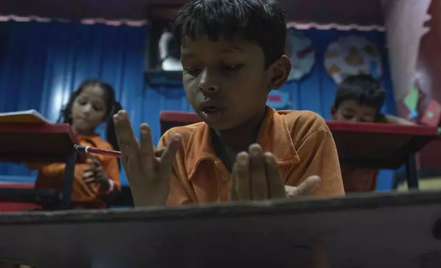 Yash Ganesh Gayakwad, 9, counts on his fingers during a math lesson at the Signal Shala school in Thane near Mumbai, India, April 9, 2025. (AP Photo/Rafiq Maqbool)