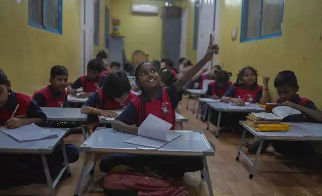 A student raises her hand during a lesson at the Signal Shala school in Thane near Mumbai, India, April 3, 2025. (AP Photo/Rafiq Maqbool)