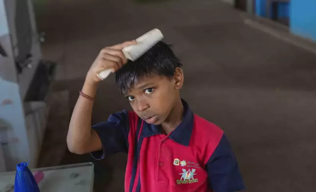 Yash Ganesh Gayakwad, 9, combs his hair after a shower at the Signal Shala school in Thane near Mumbai, India, April 5, 2025. (AP Photo/Rafiq Maqbool)