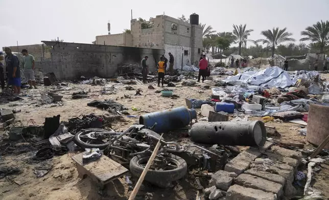 Palestinians inspect the site destroyed by Israeli airstrikes in Khan Younis, Gaza Strip, Sunday, May 18, 2025. (AP Photo/Abdel Kareem Hana)