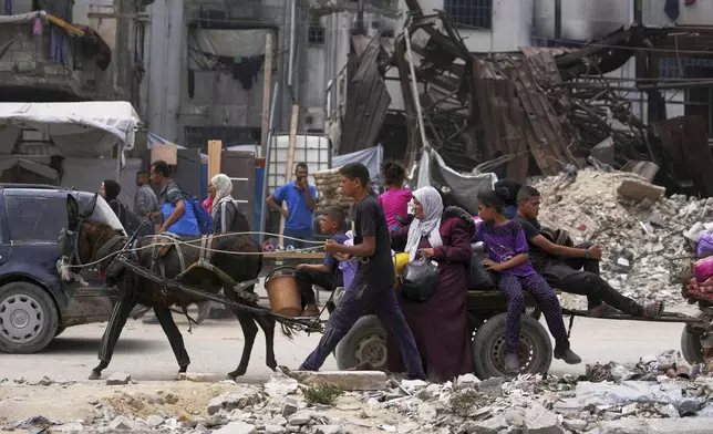 Displaced Palestinians fleeing Beit Lahia amid ongoing Israeli military operations in the Gaza Strip arrive in Jabalia, northern Gaza, on Sunday, May 18, 2025. (AP Photo/Jehad Alshrafi)