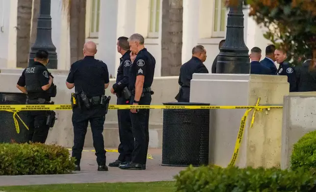 Santa Ana Police gather outside the entrance to Santa Ana High School in Santa Ana, Calif. on Wednesday, May 7, 2025, after a stabbing on campus shortly after the school day ended. (Leonard Ortiz/The Orange County Register via AP)