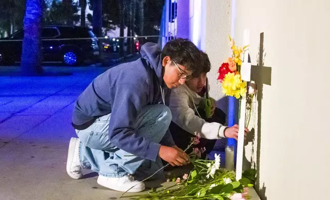 Students place flowers on a makeshift memorial near Santa Ana High School in Santa Ana, Calif. on Wednesday, May 7, 2025, after a stabbing on campus shortly after the school day ended. (Leonard Ortiz/The Orange County Register via AP)